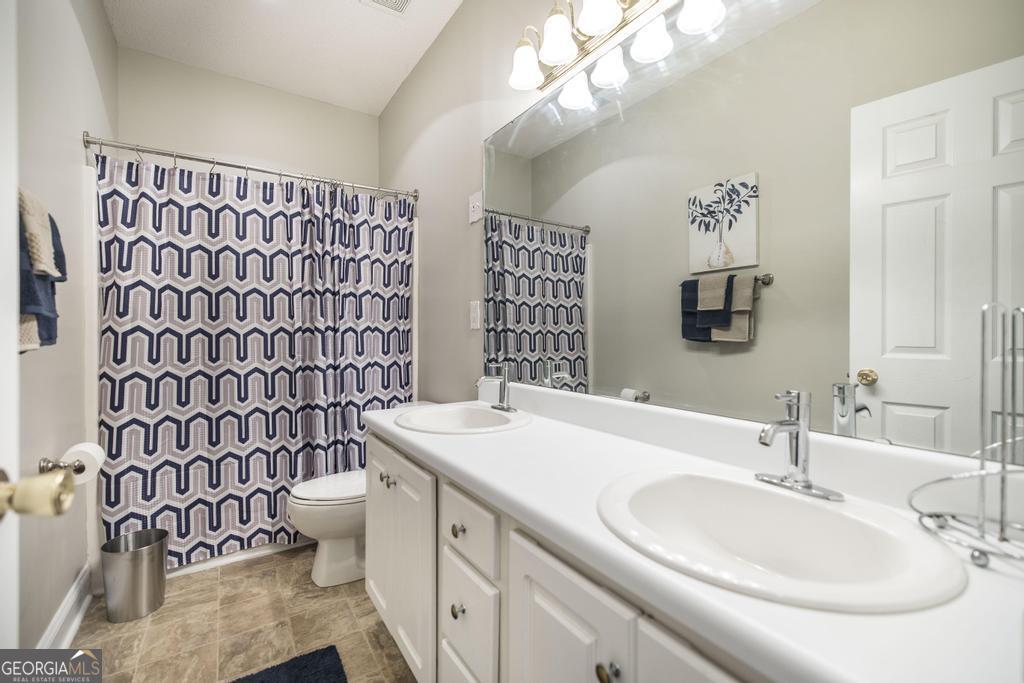 1066 Alma Drive Macon, GA 31216 - Photo 18 of 18 a bathroom with a sink a toilet and shower curtain