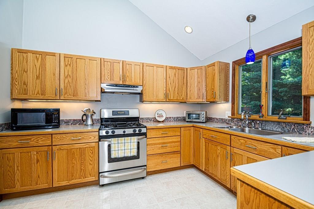 31 Woodland Road Billerica, MA 01821 - Photo 11 of 39 a kitchen with stainless steel appliances granite countertop a stove a sink and a microwave