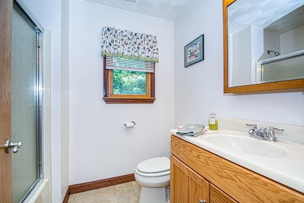 31 Woodland Road Billerica, MA 01821 - Photo 25 of 39 a bathroom with a granite countertop sink a toilet and a mirror
