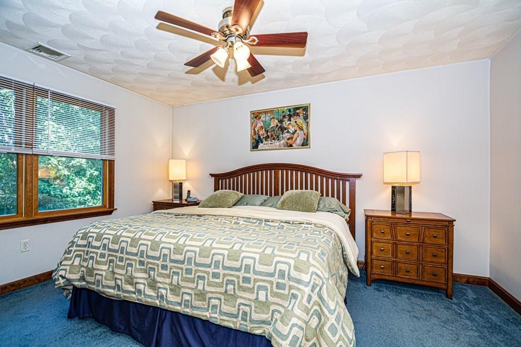 31 Woodland Road Billerica, MA 01821 - Photo 26 of 39 a bedroom with a bed chandelier and a window
