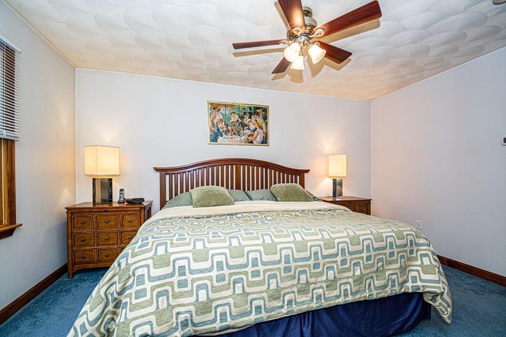 31 Woodland Road Billerica, MA 01821 - Photo 27 of 39 a bedroom with a bed and wooden floor