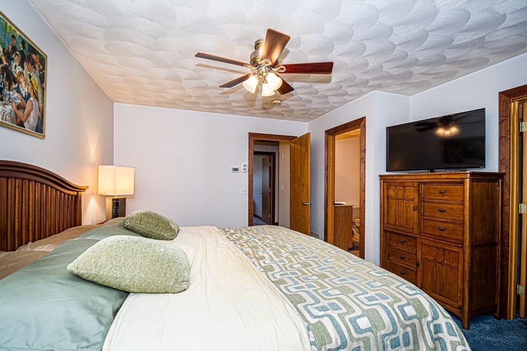31 Woodland Road Billerica, MA 01821 - Photo 29 of 39 a bedroom with a bed and a flat tv screen on dresser