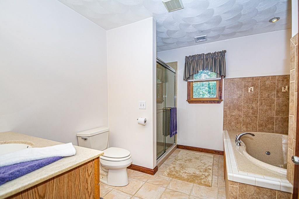 31 Woodland Road Billerica, MA 01821 - Photo 31 of 39 a bathroom with a granite countertop toilet a sink and a mirror