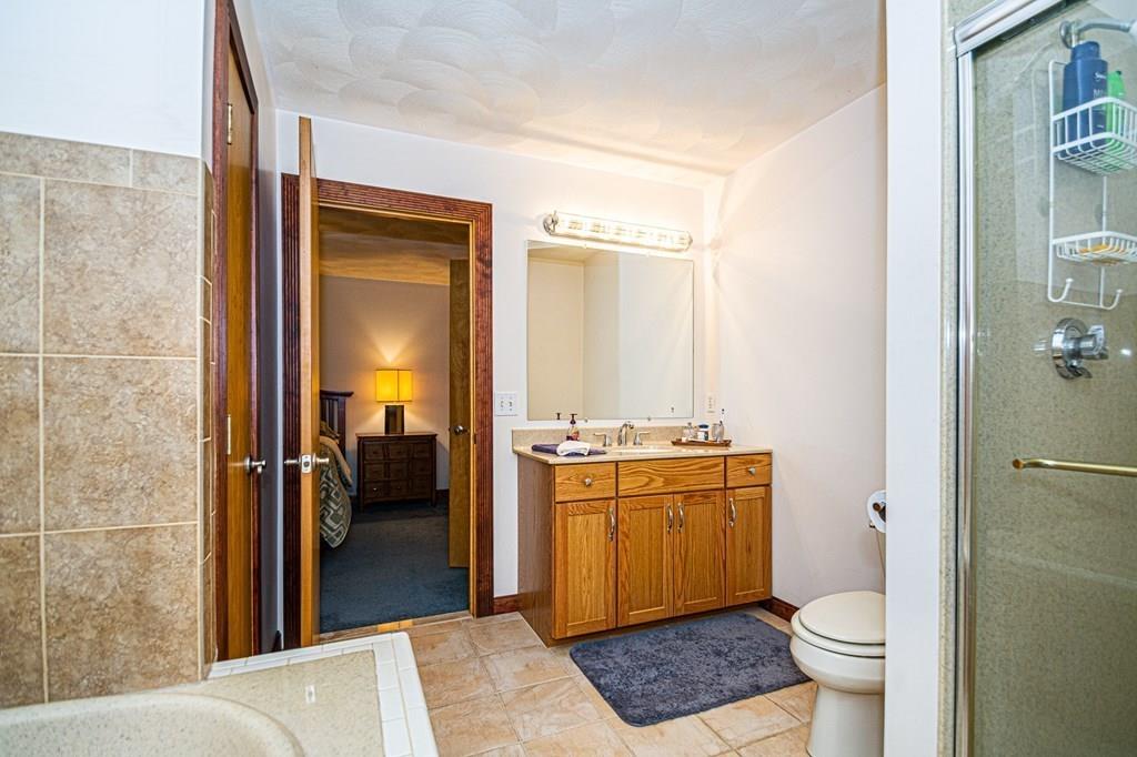 31 Woodland Road Billerica, MA 01821 - Photo 33 of 39 a bathroom with a granite countertop toilet a sink and a mirror