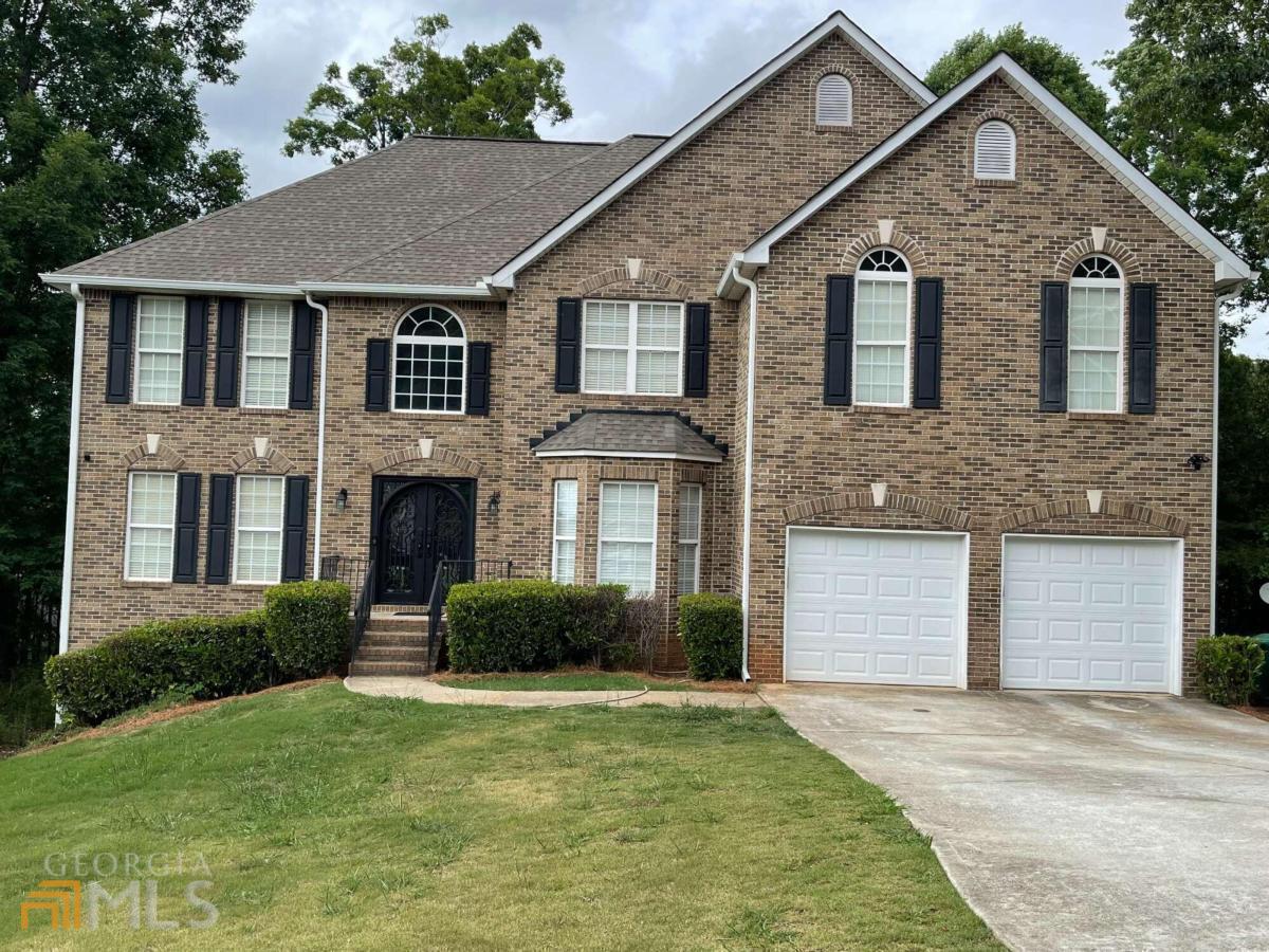 6016 Springfair Run Lithonia, GA 30038 - Photo 1 of 1 a front view of a house with a yard and garage