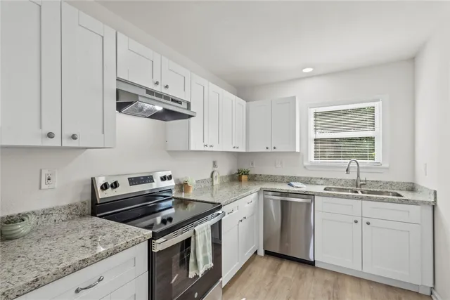 a kitchen with cabinets appliances a sink and a counter top space