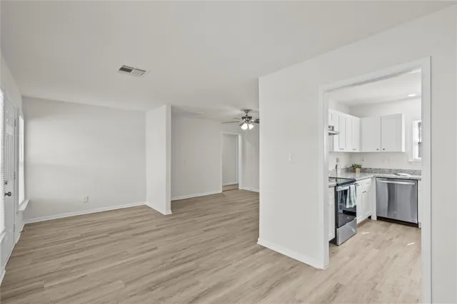 a view of a kitchen with a sink stove cabinets and empty room