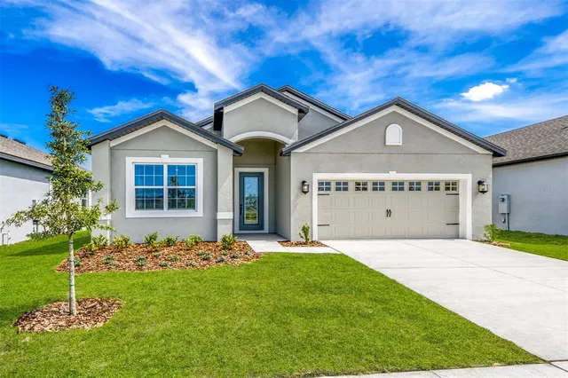 a view of a house with a big yard and potted plants