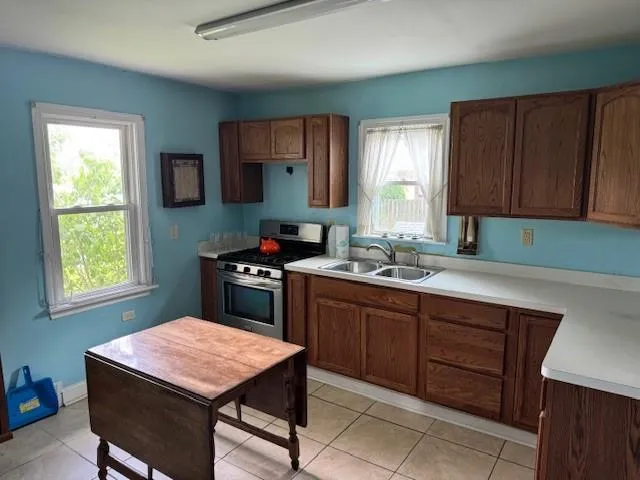 a kitchen with a stove a sink a microwave a dining table and chair