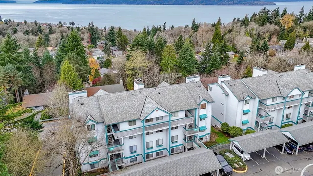 an aerial view of a house with garden and trees in the background