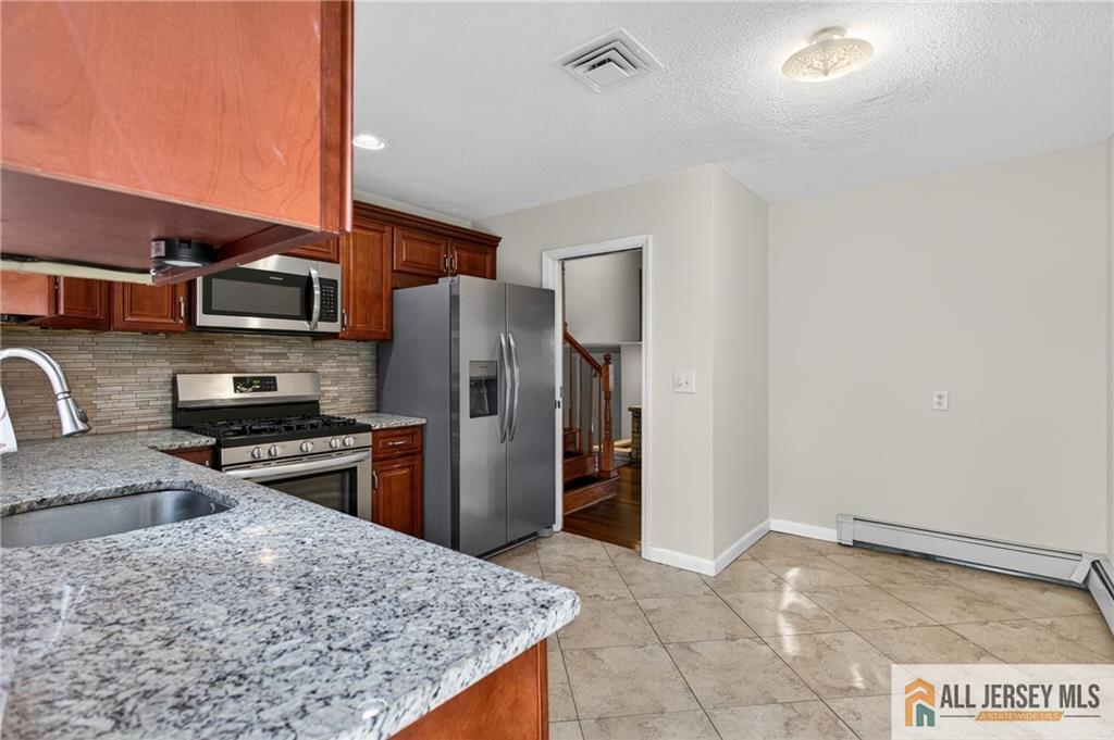 352 Rahway Road Edison, NJ 08820 - Photo 11 of 30 a kitchen with stainless steel appliances granite countertop a refrigerator stove and oven