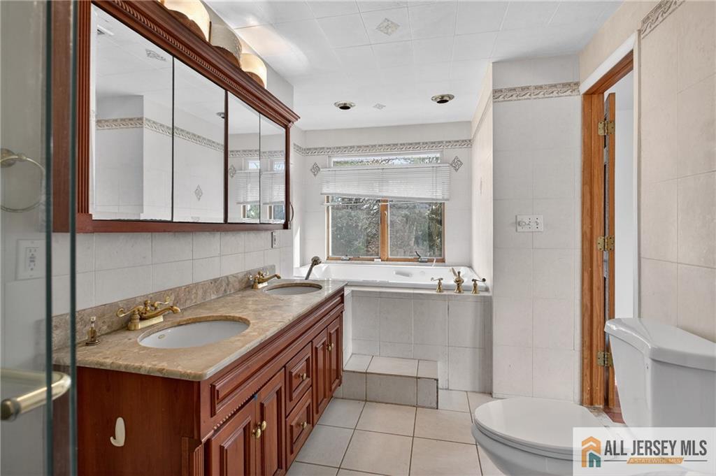 352 Rahway Road Edison, NJ 08820 - Photo 17 of 30 a bathroom with a granite countertop sink a toilet a mirror and shower