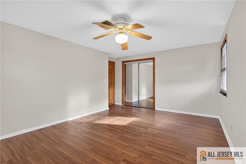 352 Rahway Road Edison, NJ 08820 - Photo 21 of 30 a view of an empty room with wooden floor and a window