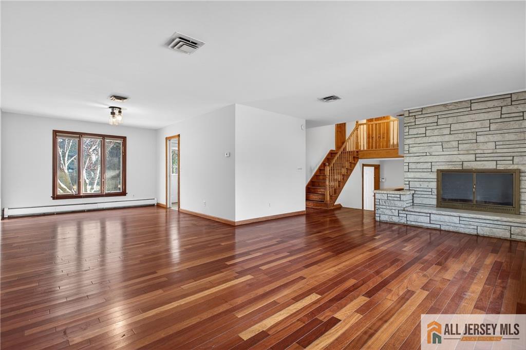 352 Rahway Road Edison, NJ 08820 - Photo 3 of 30 a view of an empty room with wooden floor fireplace and a window