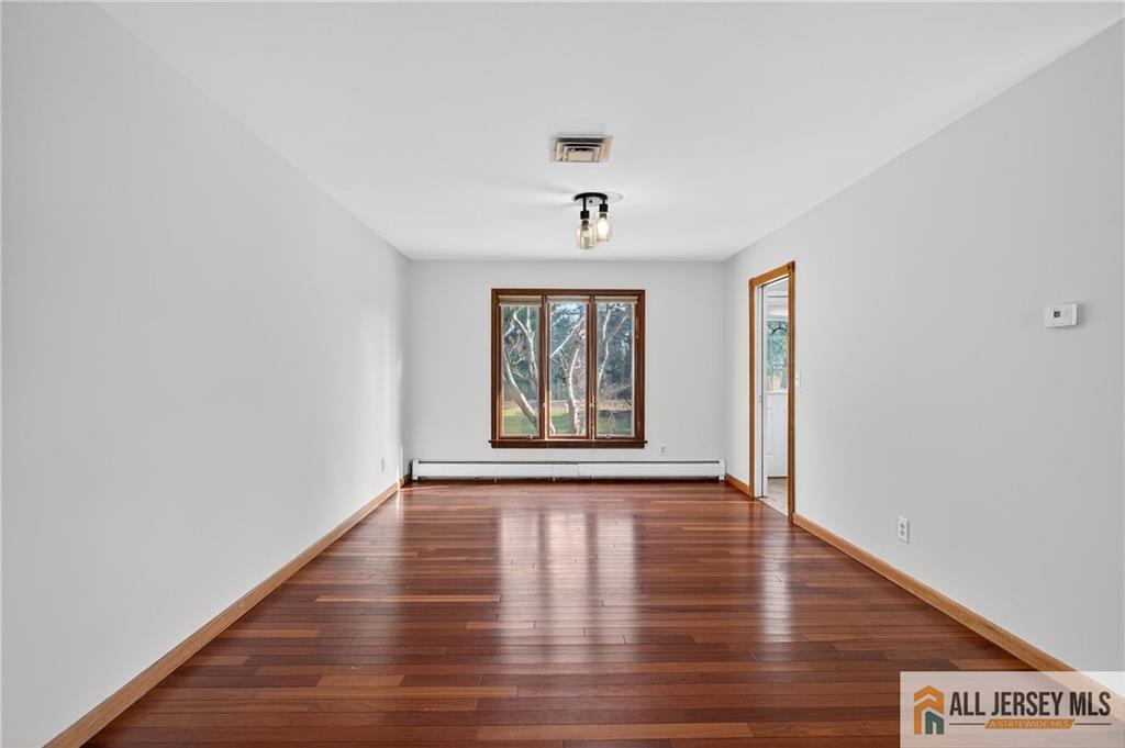 352 Rahway Road Edison, NJ 08820 - Photo 6 of 30 a view of an empty room with window and wooden floor