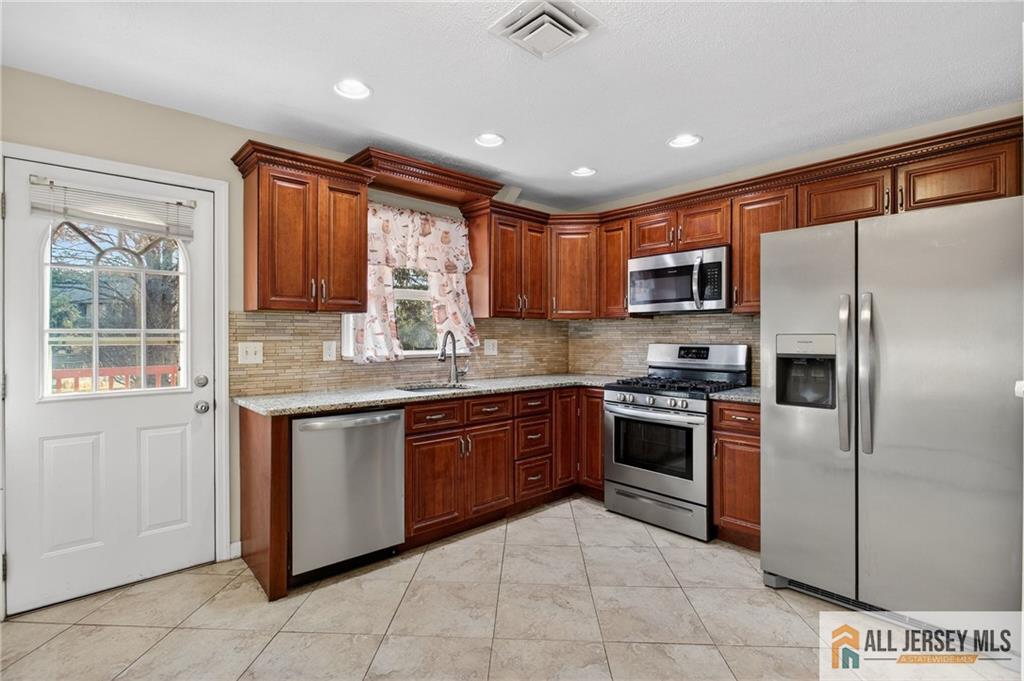 352 Rahway Road Edison, NJ 08820 - Photo 10 of 30 a large kitchen with stainless steel appliances granite countertop a stove top oven a refrigerator and a sink