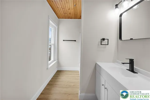 a hallway with a sink and a mirror