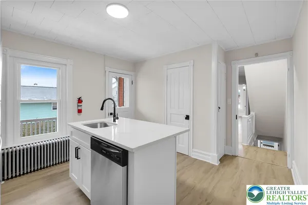 a kitchen with a sink and a wooden floor