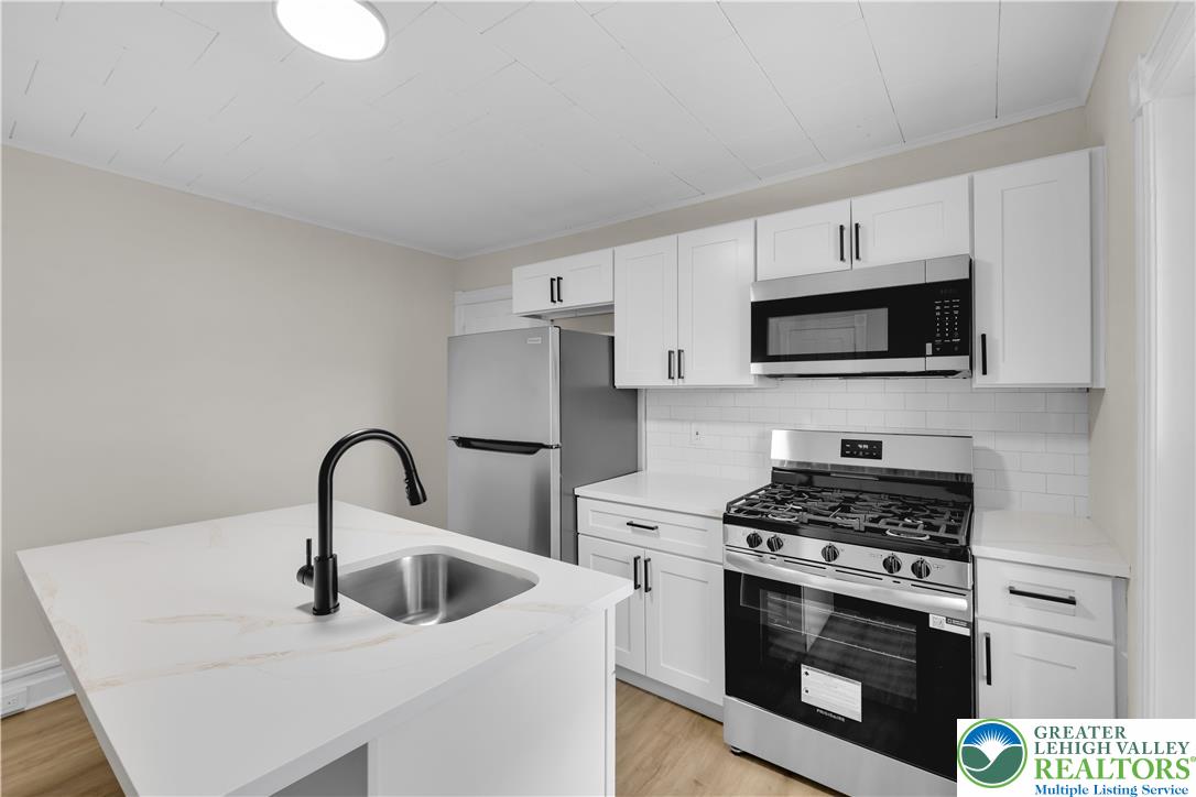 109 North Sixth Street Emmaus, PA 18049 - Photo 16 of 23 a kitchen with stainless steel appliances a stove a sink and white cabinets