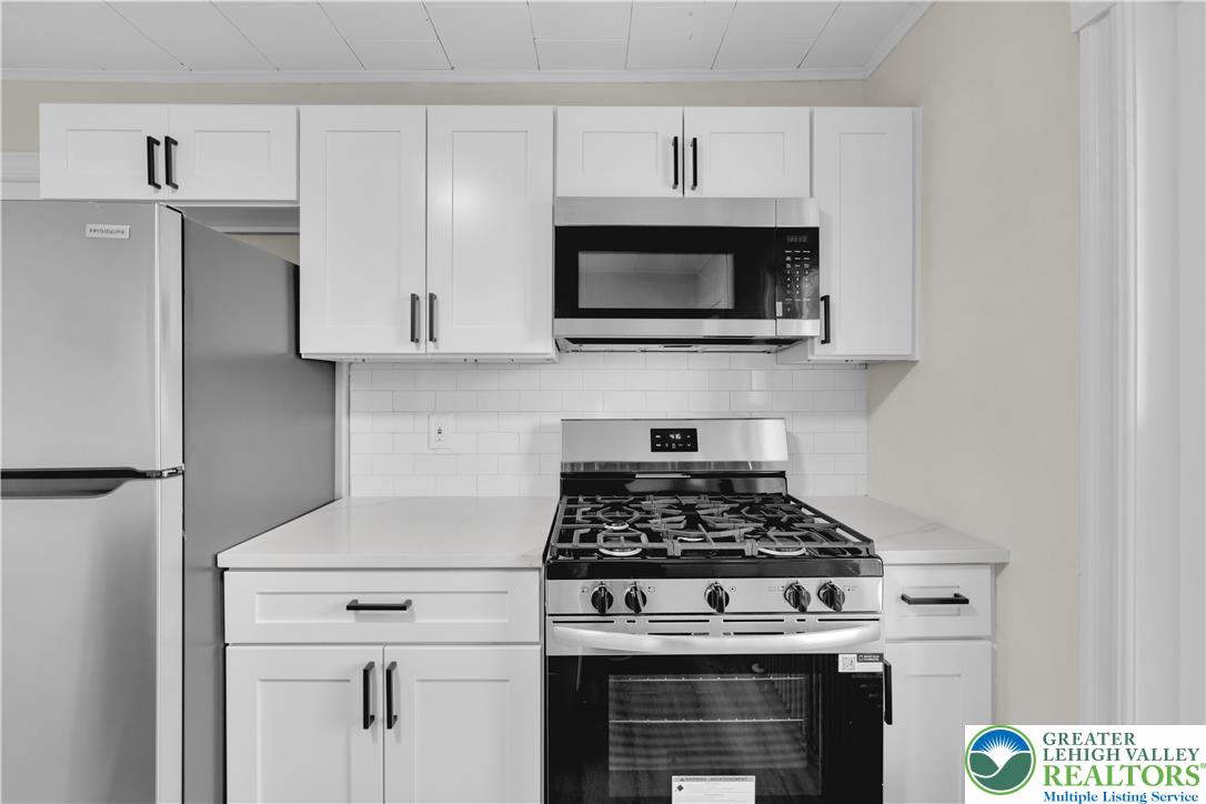 109 North Sixth Street Emmaus, PA 18049 - Photo 18 of 23 a kitchen with stainless steel appliances granite countertop white cabinets a stove a microwave and a refrigerator