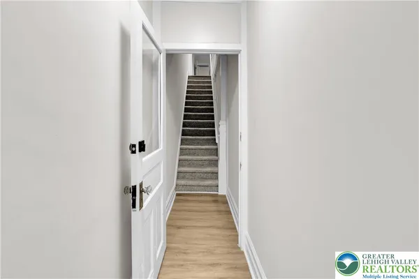 a view of a hallway with wooden floor and entryway