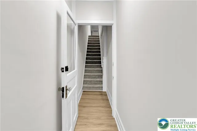 a view of a hallway with wooden floor and entryway