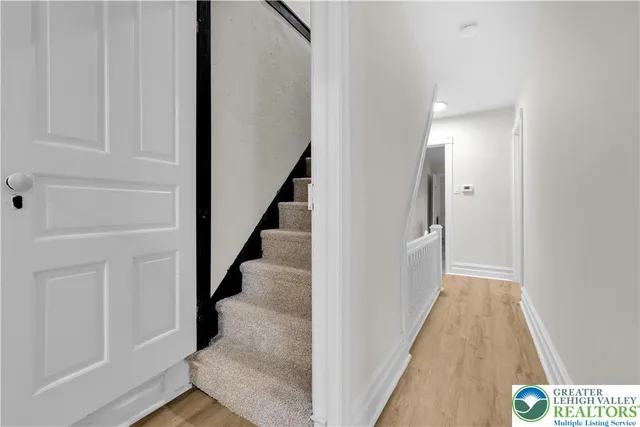 a view of a hallway with wooden floor and entryway