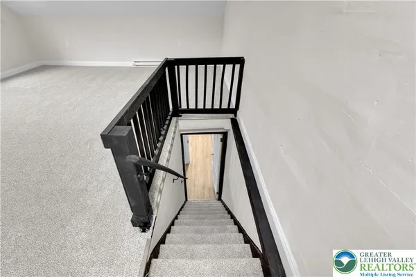 a view of staircase with railing and white walls
