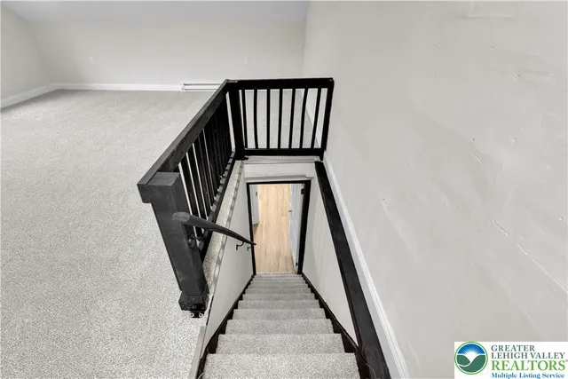 a view of staircase with railing and white walls