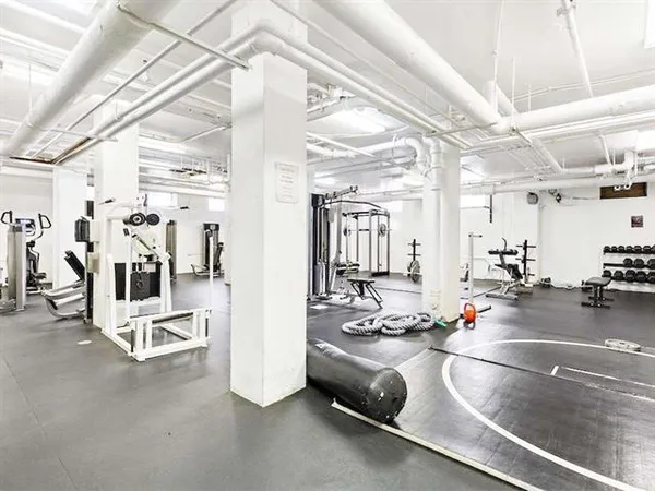 a view of gym equipment and living room with lots of gym equipment