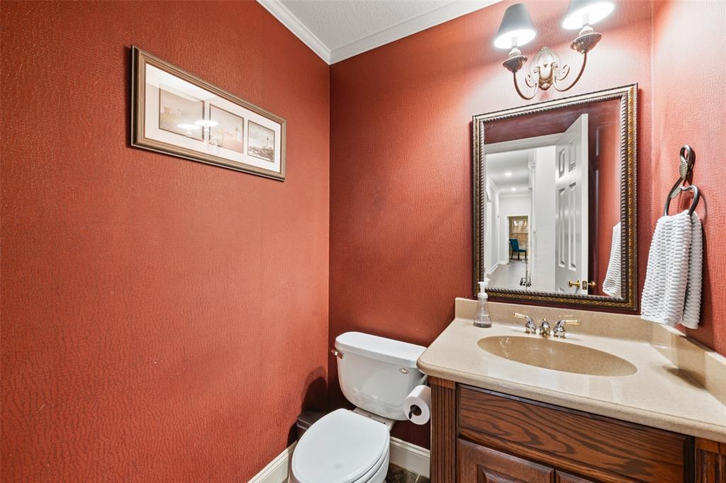 517 Chado Lane Robinson, TX 76706 - Photo 16 of 40 Half bathroom featuring vanity, crown molding, and a textured wall