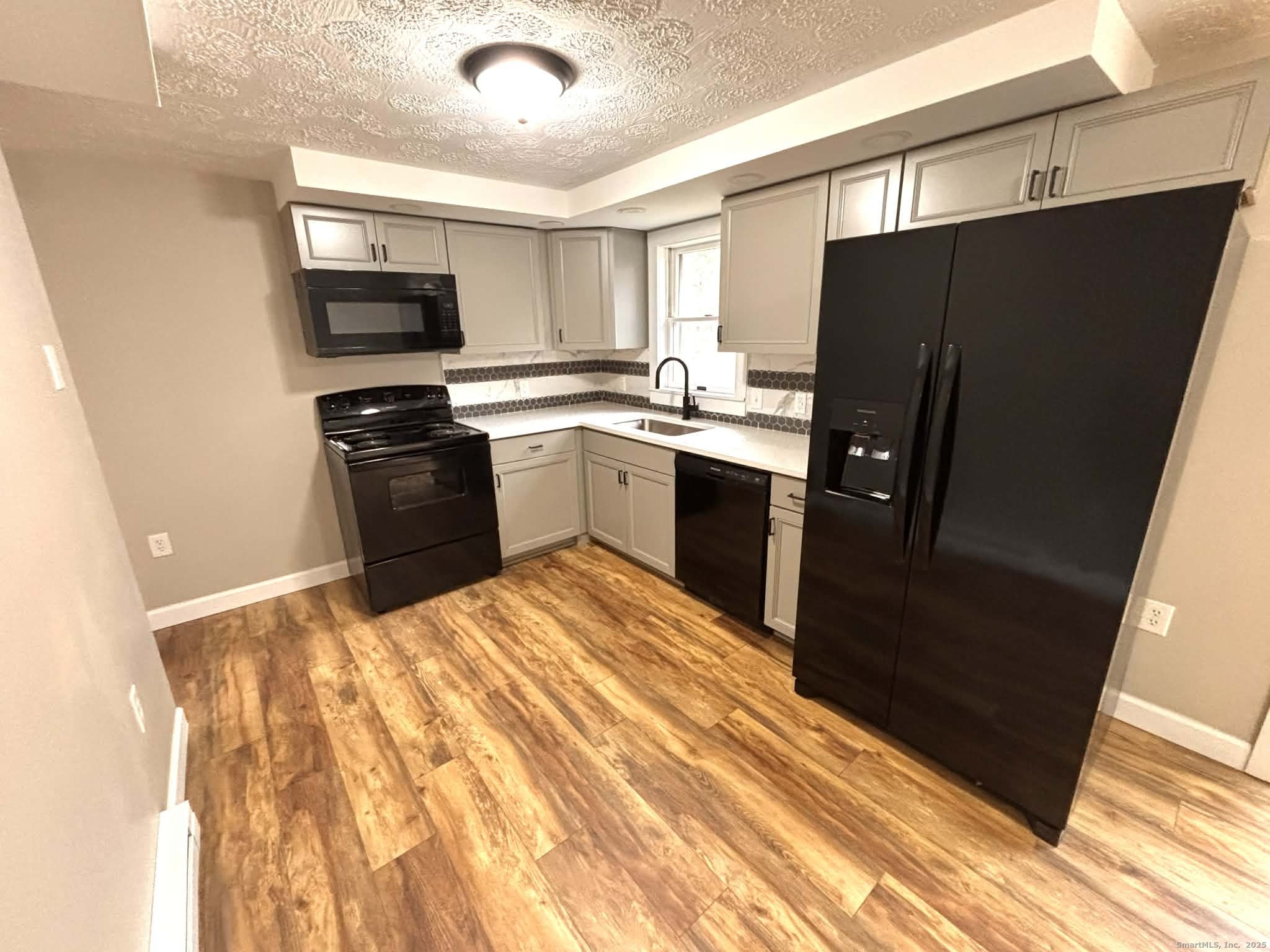 164 Starkweather Road Plainfield, CT 06354 - Photo 5 of 23 a kitchen with granite countertop a refrigerator stove and microwave