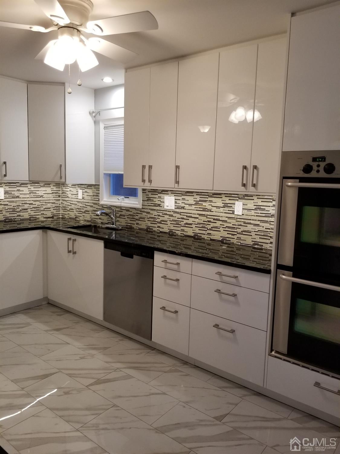 1551 Barton Road Union, NJ 07083 - Photo 2 of 7 a kitchen with a sink stainless steel appliances and cabinets