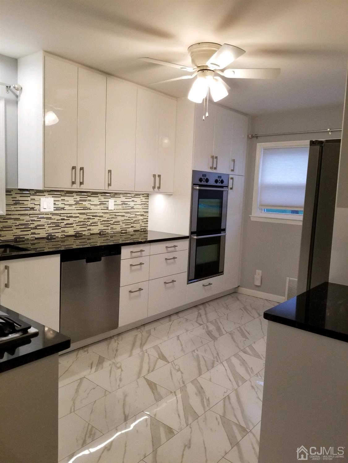 1551 Barton Road Union, NJ 07083 - Photo 3 of 7 a kitchen with stainless steel appliances granite countertop a stove a sink and a refrigerator