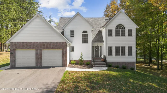 a view of a yard in front of a house with a large tree
