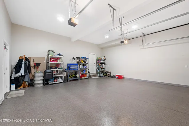 a kitchen with refrigerator and chairs