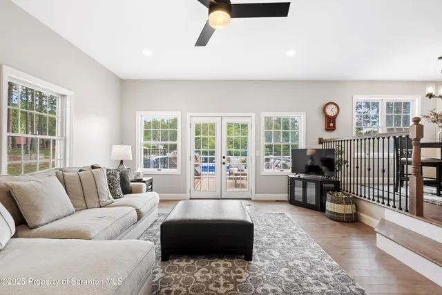 a view of a dining room and livingroom with furniture wooden floor a chandelier