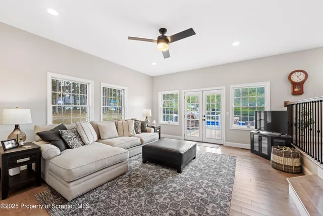 a kitchen with stainless steel appliances granite countertop a refrigerator a sink dishwasher a stove and white cabinets with wooden floor