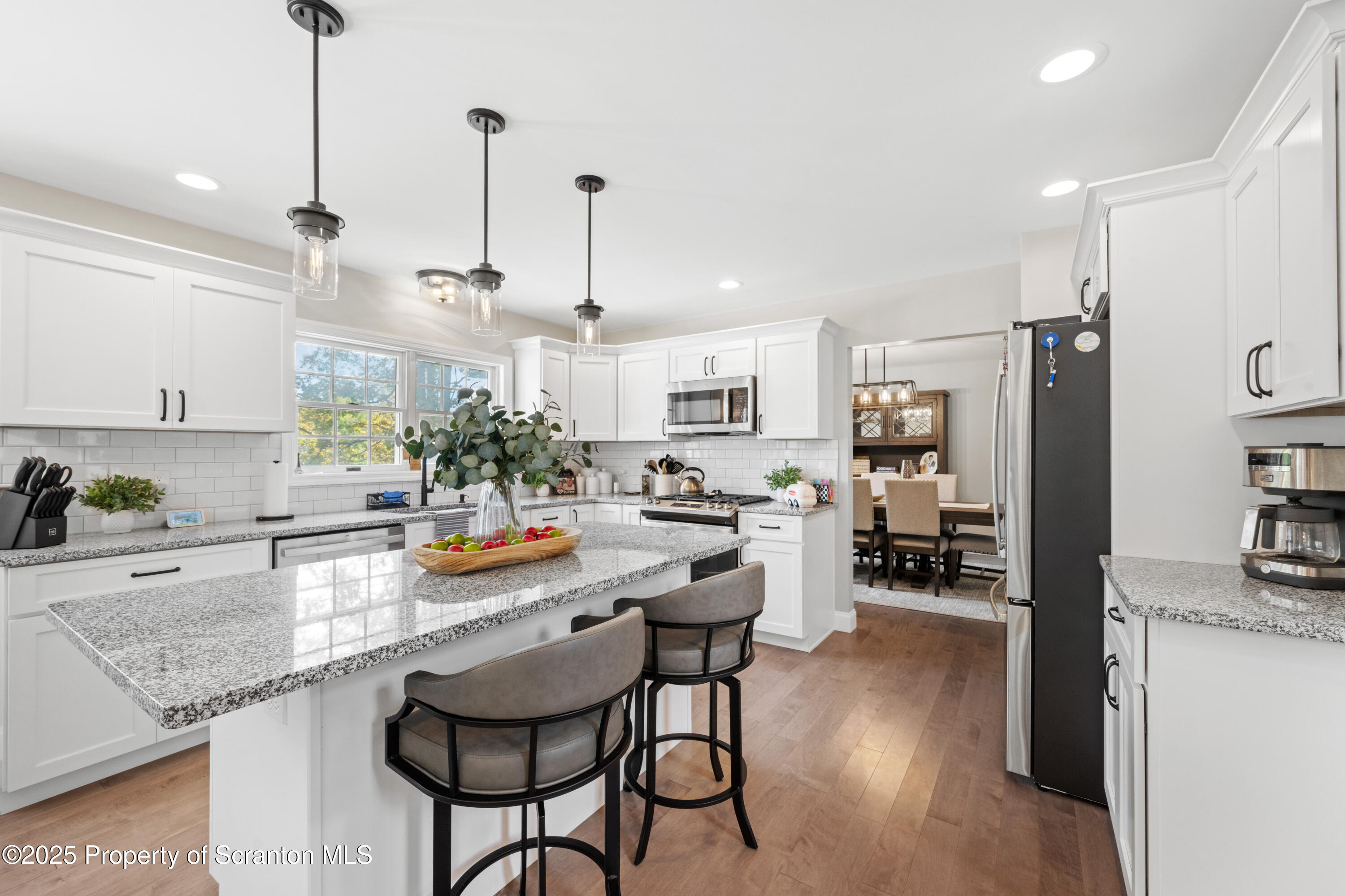 220 Fuller Road Dalton, PA 18414 - Photo 38 of 55 a kitchen with stainless steel appliances granite countertop a refrigerator a sink dishwasher a stove and white cabinets with wooden floor