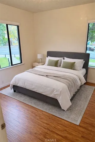 a bedroom with a bed and wooden floor