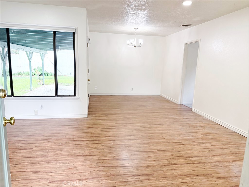 18424 Calvert Street Tarzana, CA 91335 - Photo 3 of 25 a view of an empty room with wooden floor and a window