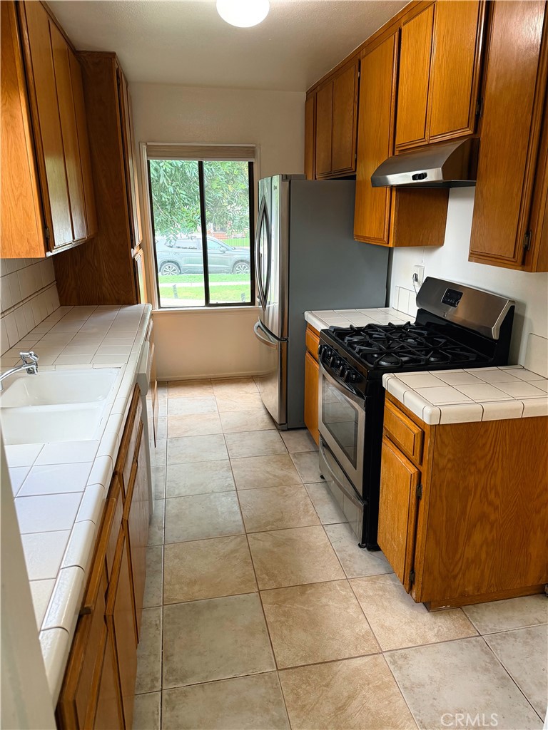18424 Calvert Street Tarzana, CA 91335 - Photo 4 of 25 a kitchen with a stove a sink and a refrigerator