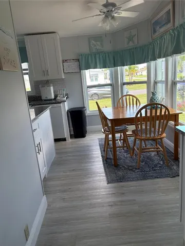 a dining room with furniture and a large window