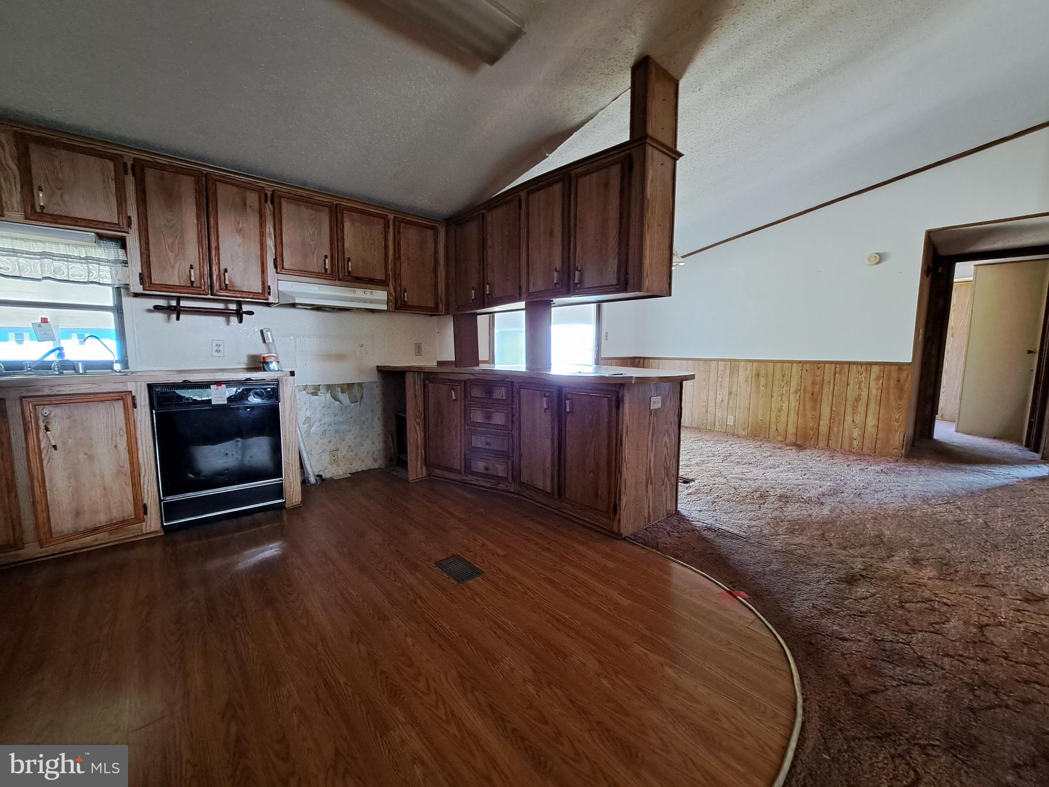 6706 Whiteley Road Hurlock, MD 21643 - Photo 11 of 45 a kitchen with wooden floors and wooden cabinets