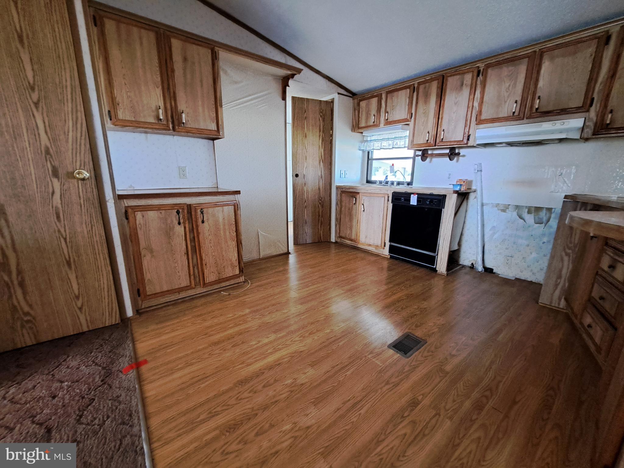 6706 Whiteley Road Hurlock, MD 21643 - Photo 12 of 45 a kitchen with granite countertop wooden floors and a refrigerator
