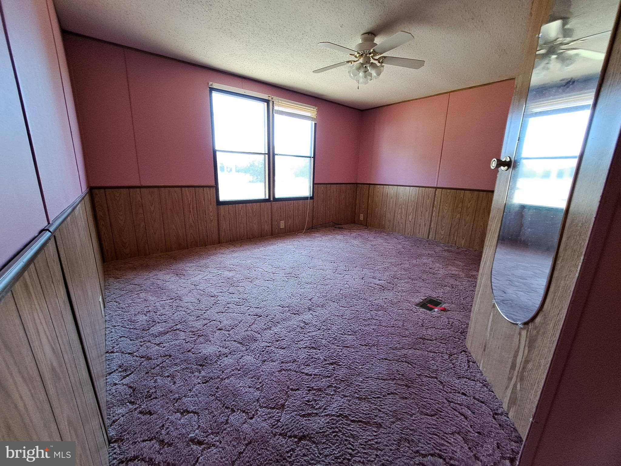 6706 Whiteley Road Hurlock, MD 21643 - Photo 20 of 45 an empty room with windows and fan