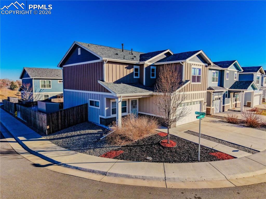 7956 Osage Street Denver, CO 80221 - Photo 1 of 48 View of front facade featuring concrete driveway, a garage, a residential view, and board and batten siding