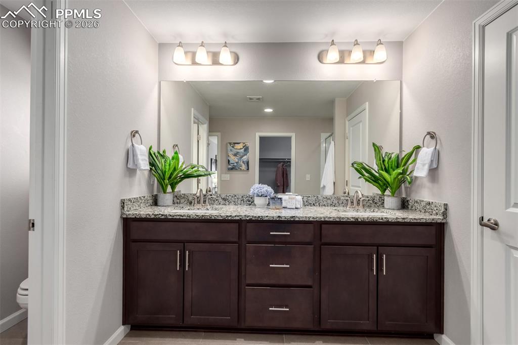 7956 Osage Street Denver, CO 80221 - Photo 23 of 48 Full bathroom with double vanity and a spacious closet