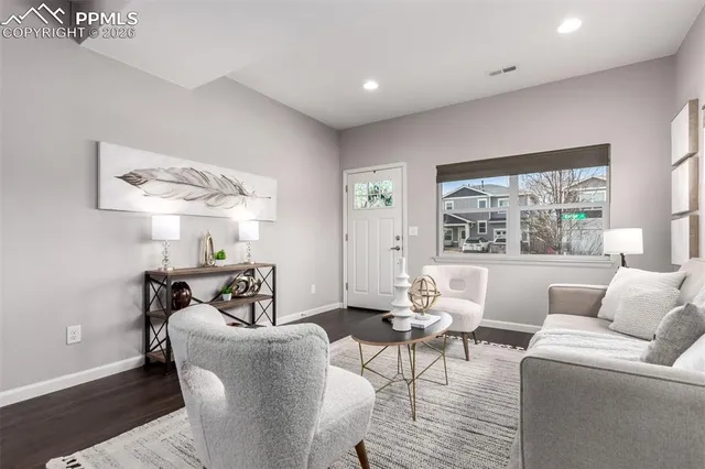 a dining room with wooden floor a chandelier a glass table and chairs