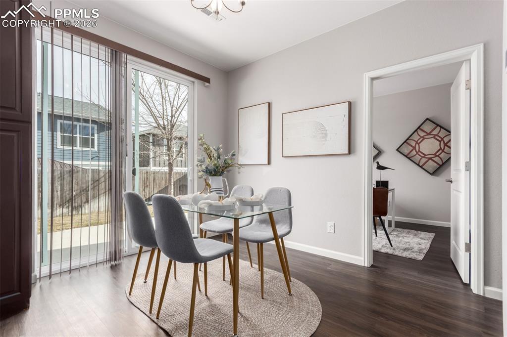 7956 Osage Street Denver, CO 80221 - Photo 7 of 48 Dining space with dark wood finished floors and a chandelier
